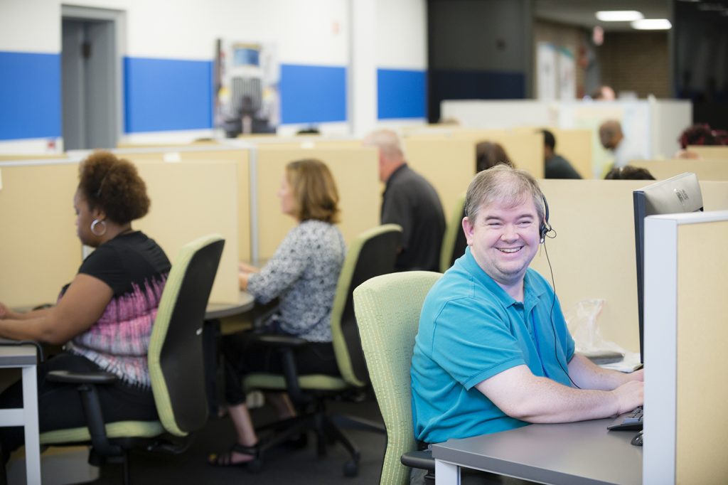 Lighthouse Enterprises contact center agents wearing headsets at workstations on the operations floor