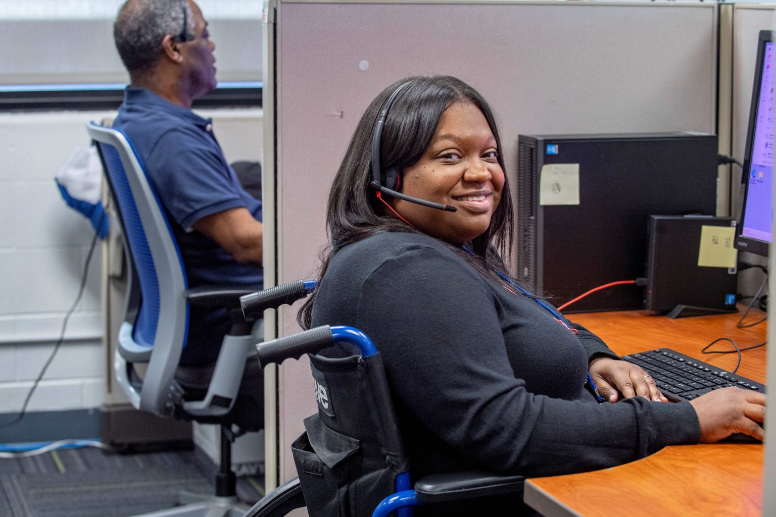 Lighthouse Enterprises agent smiling at her workstation on the contact center floor